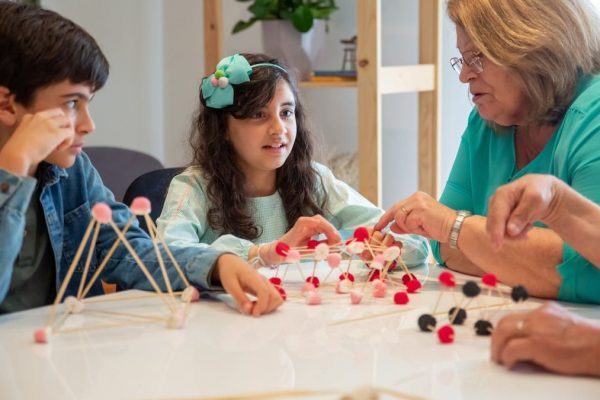Grandmother playing educational games with grandchildren indoors, fostering creativity and learning.