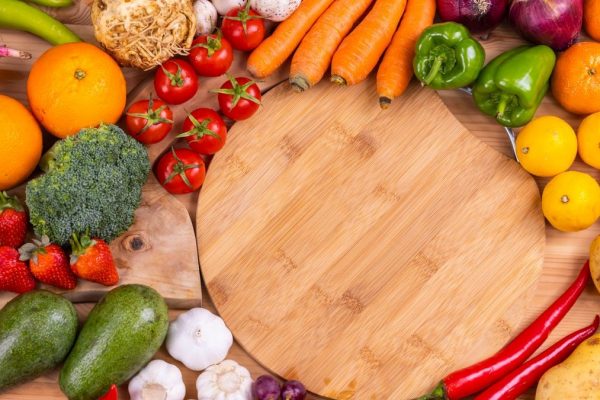 Discover a vibrant assortment of fresh fruits and vegetables arranged on a wooden board. Perfect for healthy eating inspiration.