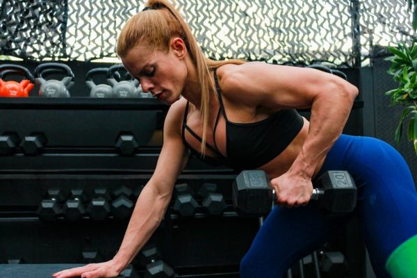 A fit woman lifting weights in a gym setting illustrating determination and strength.
